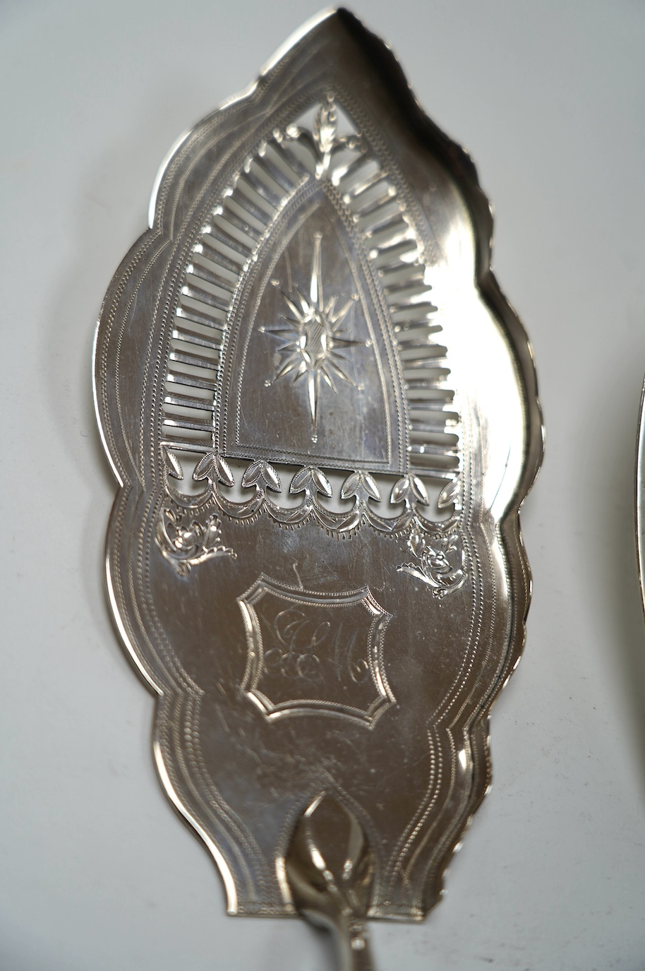 A George III silver fish slice with part gallery border, Henry Chawner, London, 1791, 30.4cm and a later George IV silver King's pattern fish slice, London, 1821. Condition - poor to fair